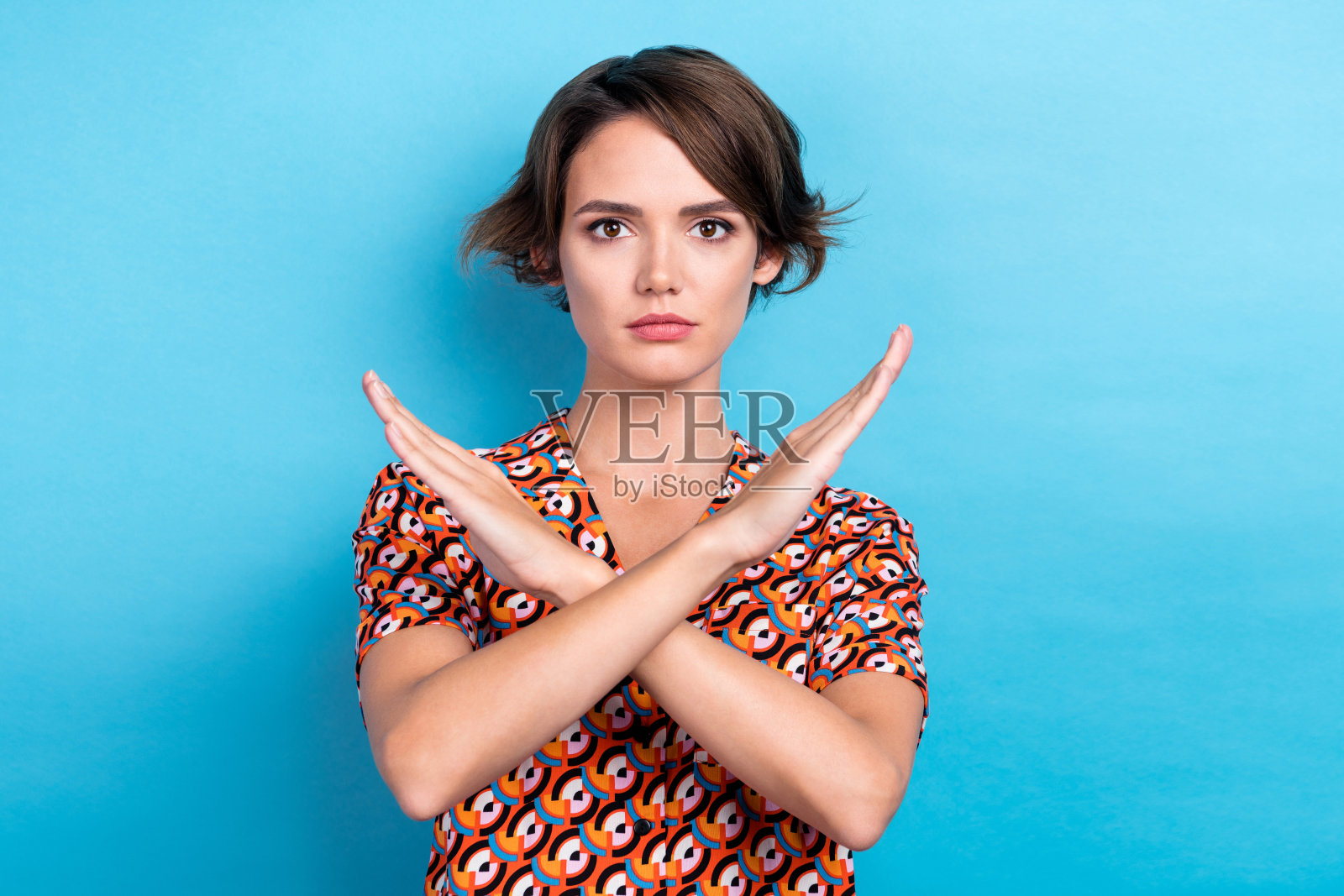 照片中严肃自信的女士穿着印花衬衫双臂交叉询问停止孤立的蓝色背景照片摄影图片