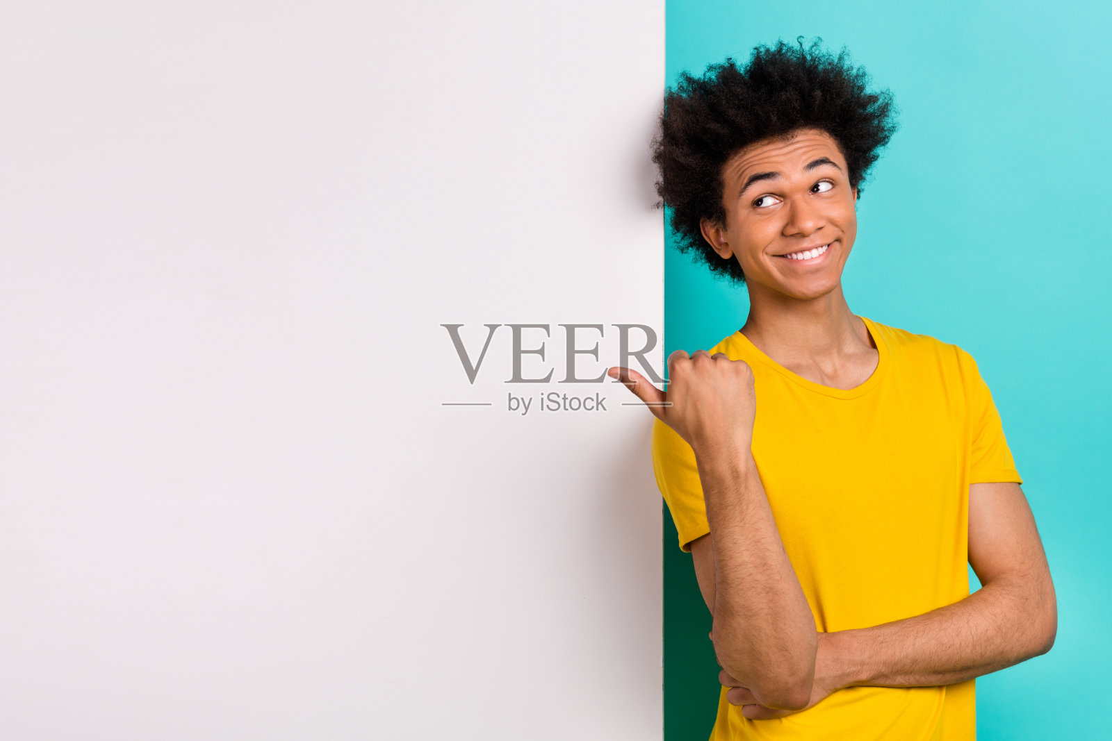 好心情的肖像好男人穿黄色t恤看指导空白空间靠墙孤立在充满活力的蓝绿色背景照片摄影图片