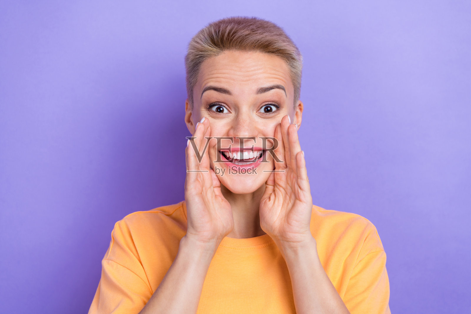 肖像正面迷人的人双手靠近嘴，露齿微笑说，告诉新闻孤立在紫色的背景照片摄影图片