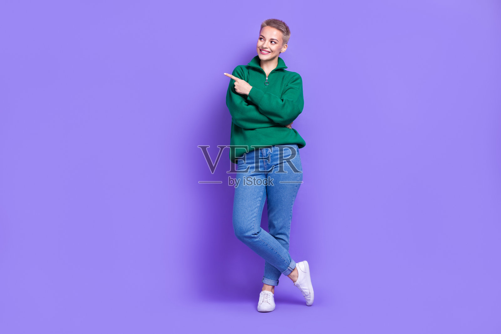 漂亮梦幻的女人穿着绿色套头衫的全长照片，显示手指空白的空间孤立的紫色背景照片摄影图片