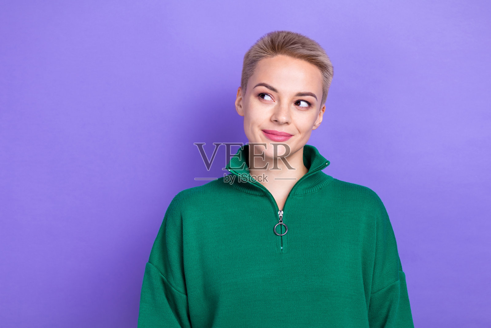 梦幻可爱的照片自信的金发女士穿绿色时尚的毛衣看模型想要新的礼物销售广告孤立的紫色背景照片摄影图片