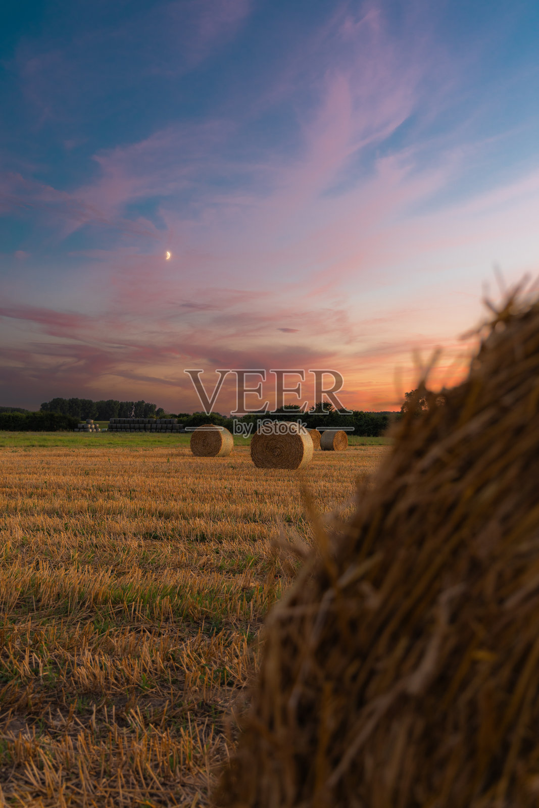 日落时田野里的干草捆照片摄影图片
