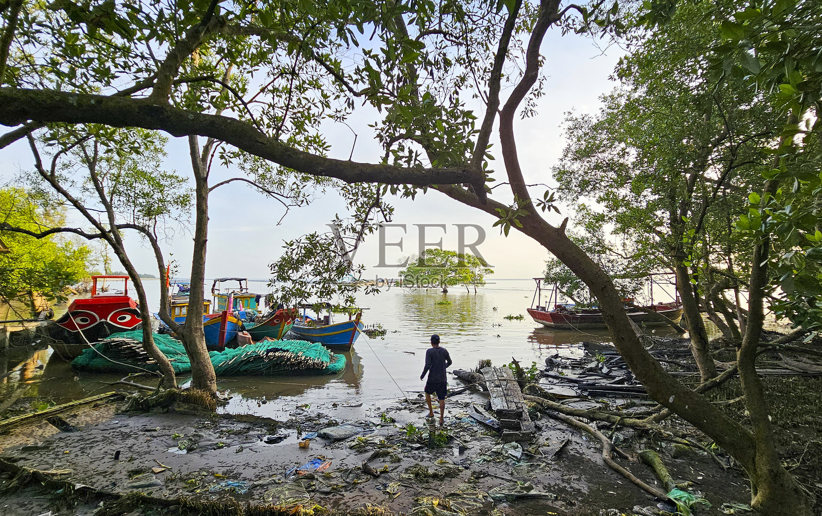 渔民们正准备出海，渔船停泊在有许多红树林的海滩上，天江省Tan Thanh海滩。照片摄影图片
