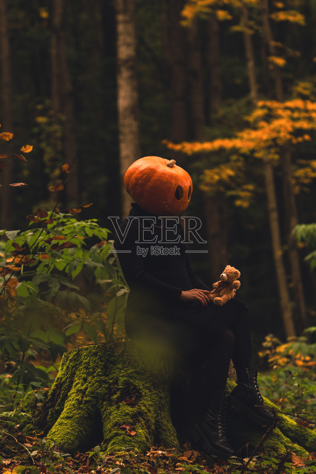带着玩具的南瓜头鬼女人在森林里照片摄影图片