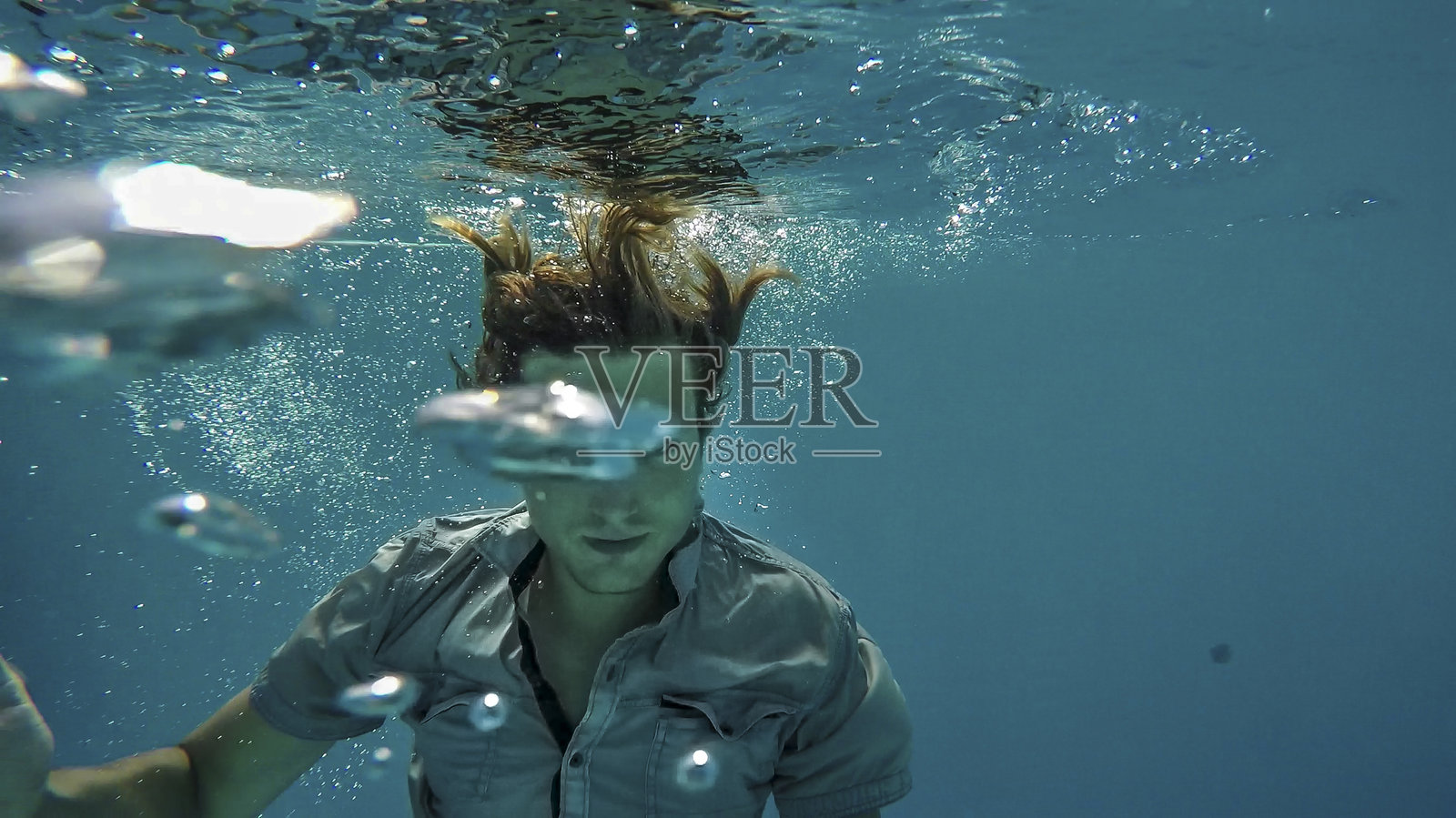 在游泳池游泳的年轻人照片摄影图片