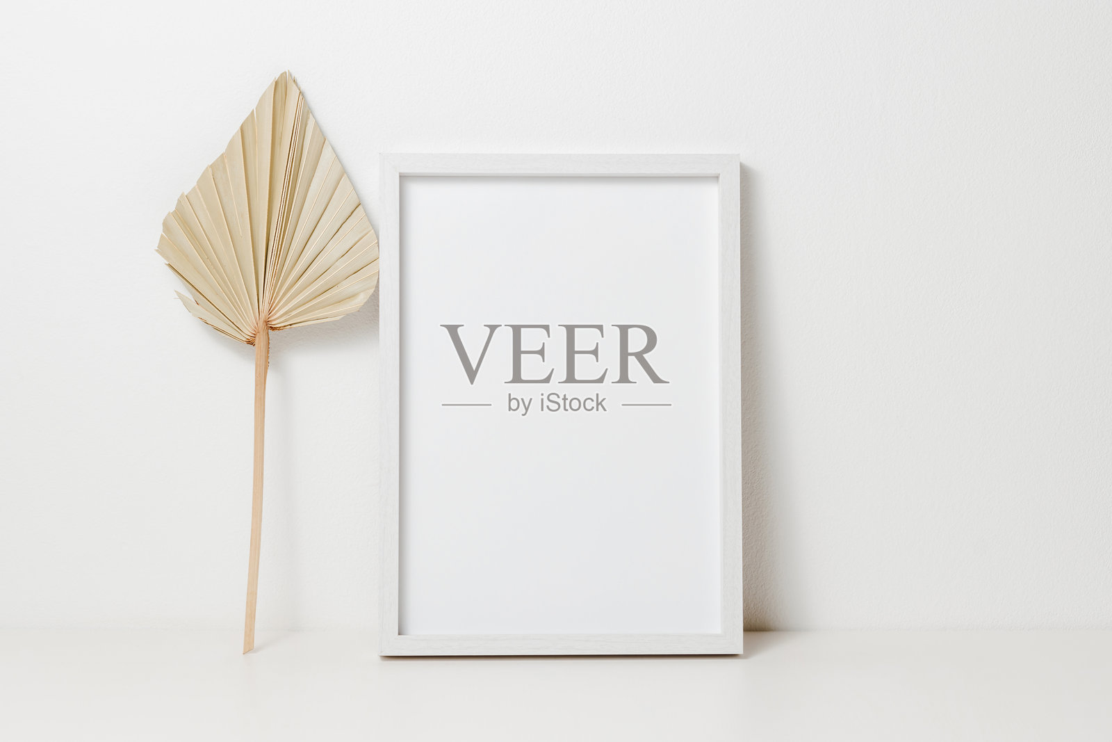 白色桌子上的棕榈叶木制模型相框。照片摄影图片