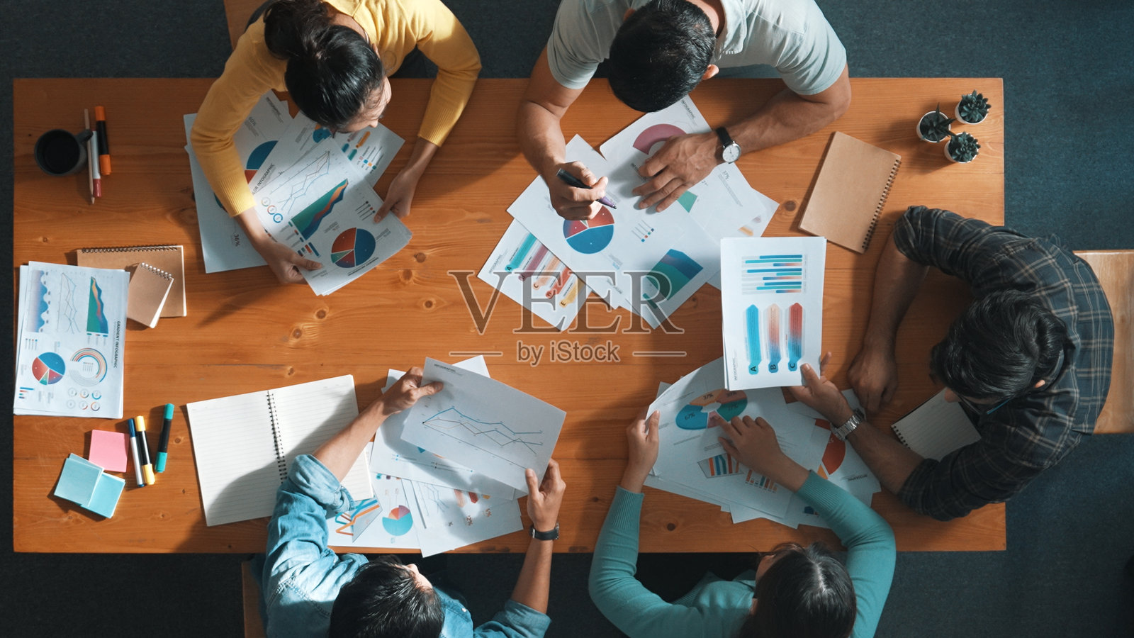 创业团队拿着文件讨论创意的俯视图。研讨会。照片摄影图片