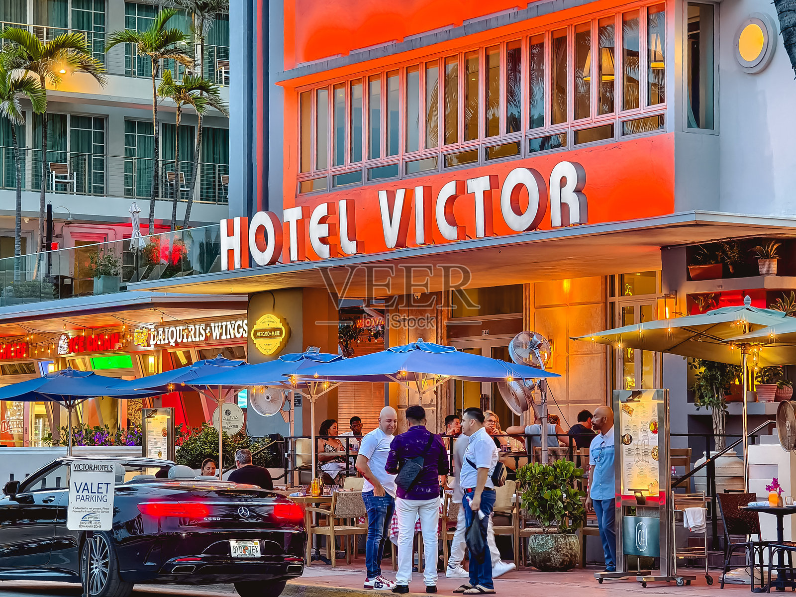 迈阿密海滩，佛罗里达州——晚上人们在南海滩维克多酒店外社交照片摄影图片