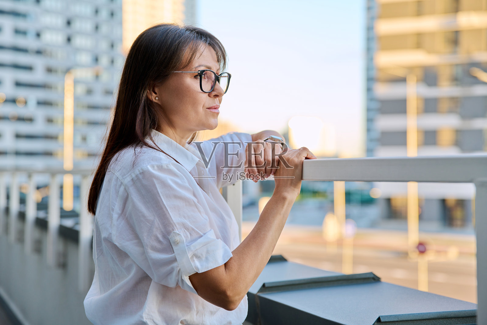 中年自信女性在户外摆姿势的肖像，侧面视图照片摄影图片