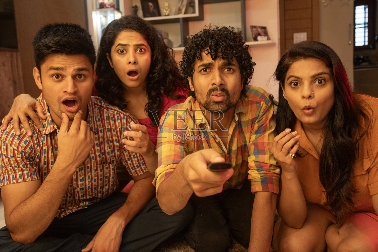 年轻的朋友们在家里紧张地看比赛照片摄影图片