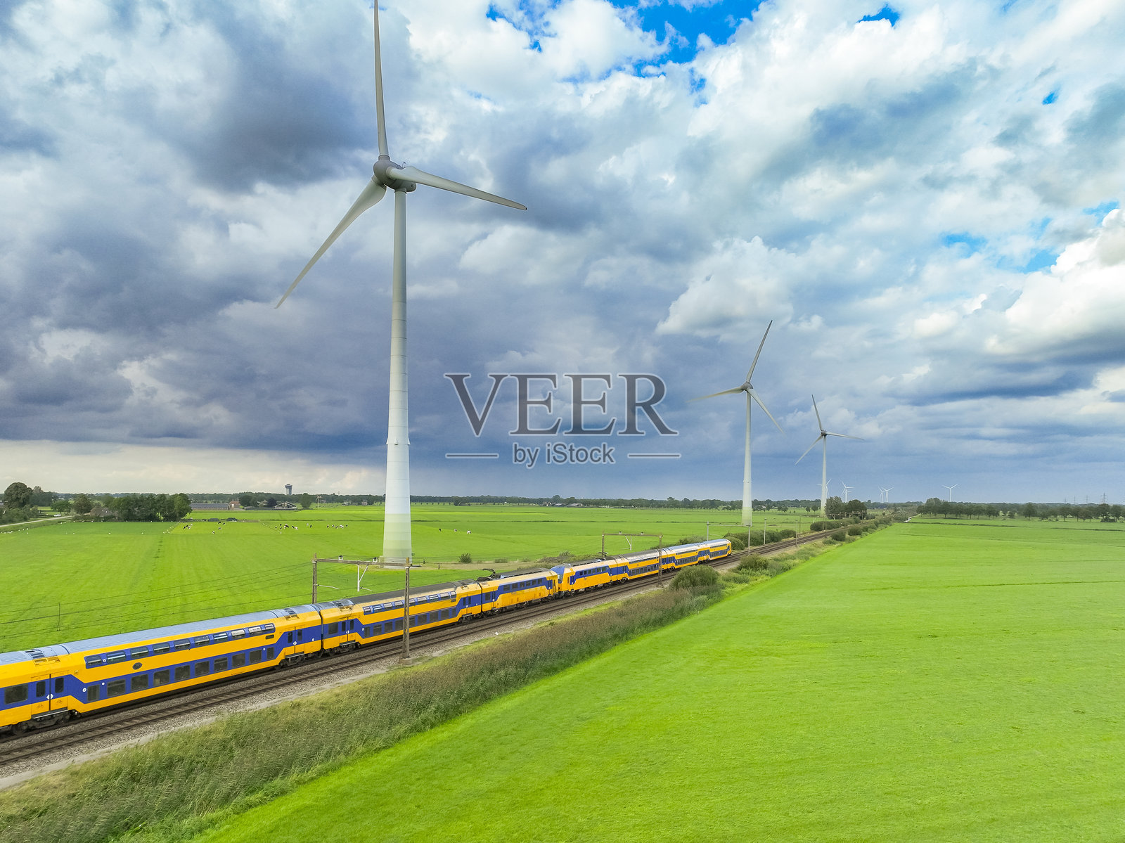 荷兰铁路的火车驶过风力涡轮机照片摄影图片