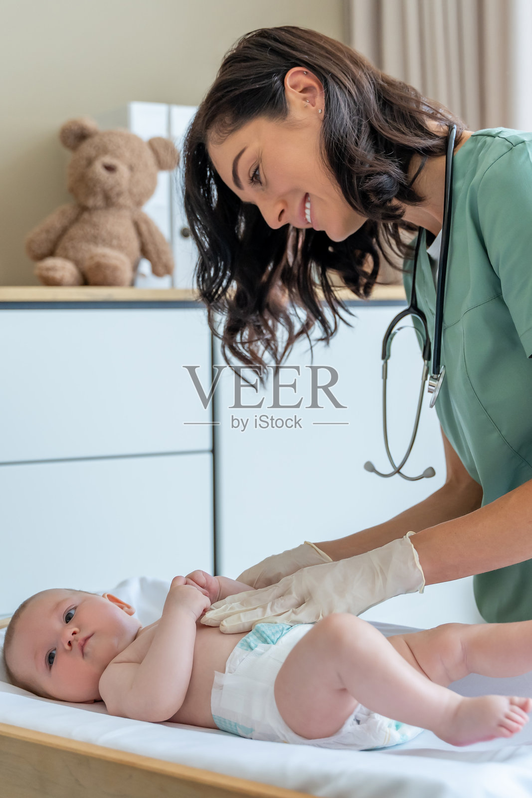 女儿科医生每月在医院检查新生儿照片摄影图片