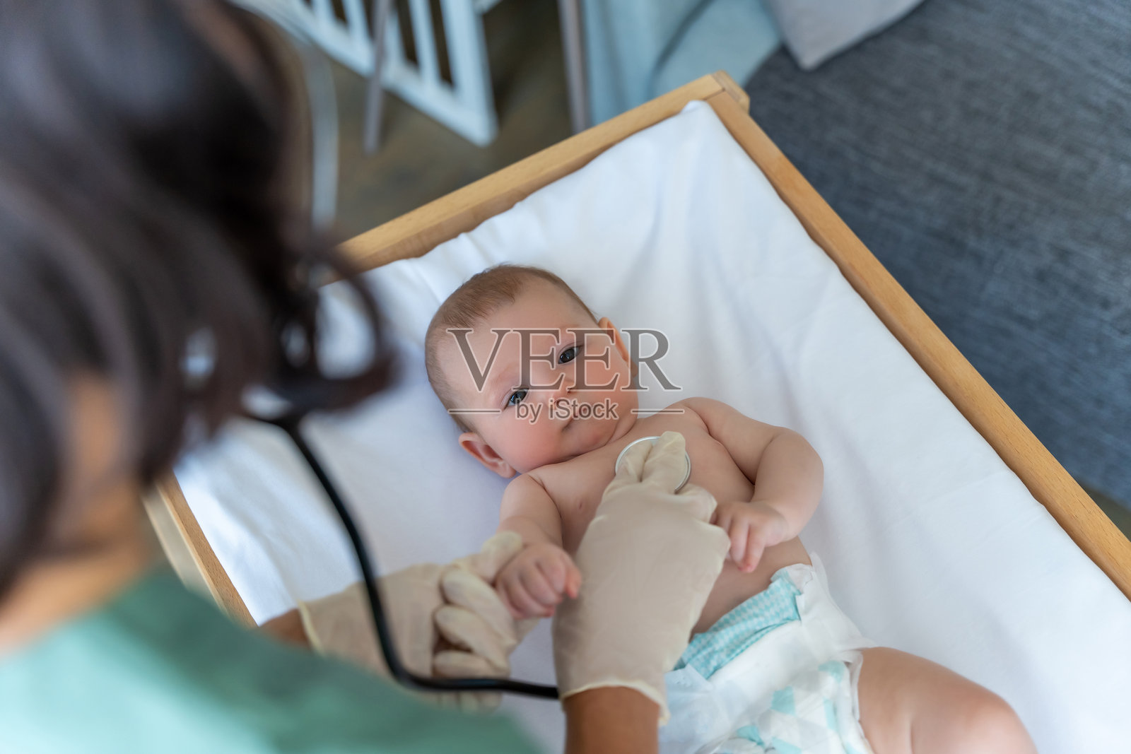 不知名的女儿科医生正在给婴儿做健康检查照片摄影图片