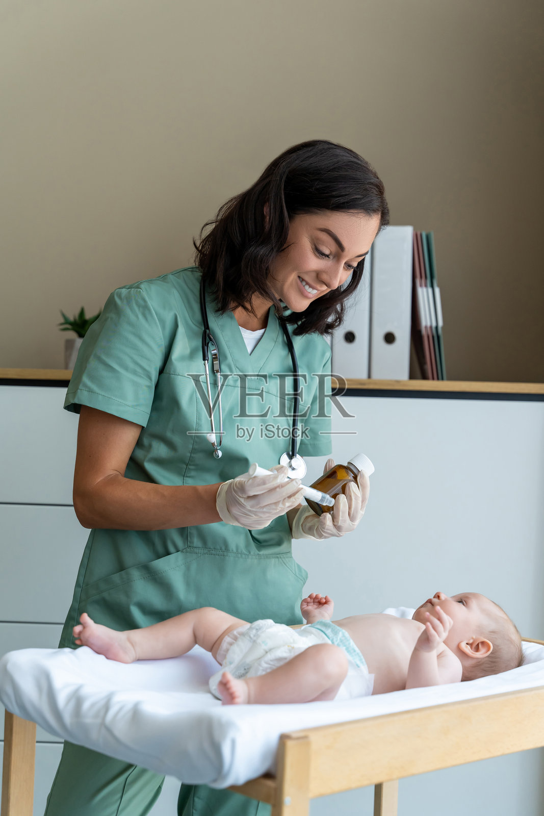 护士在病房里给新生儿口服药物照片摄影图片