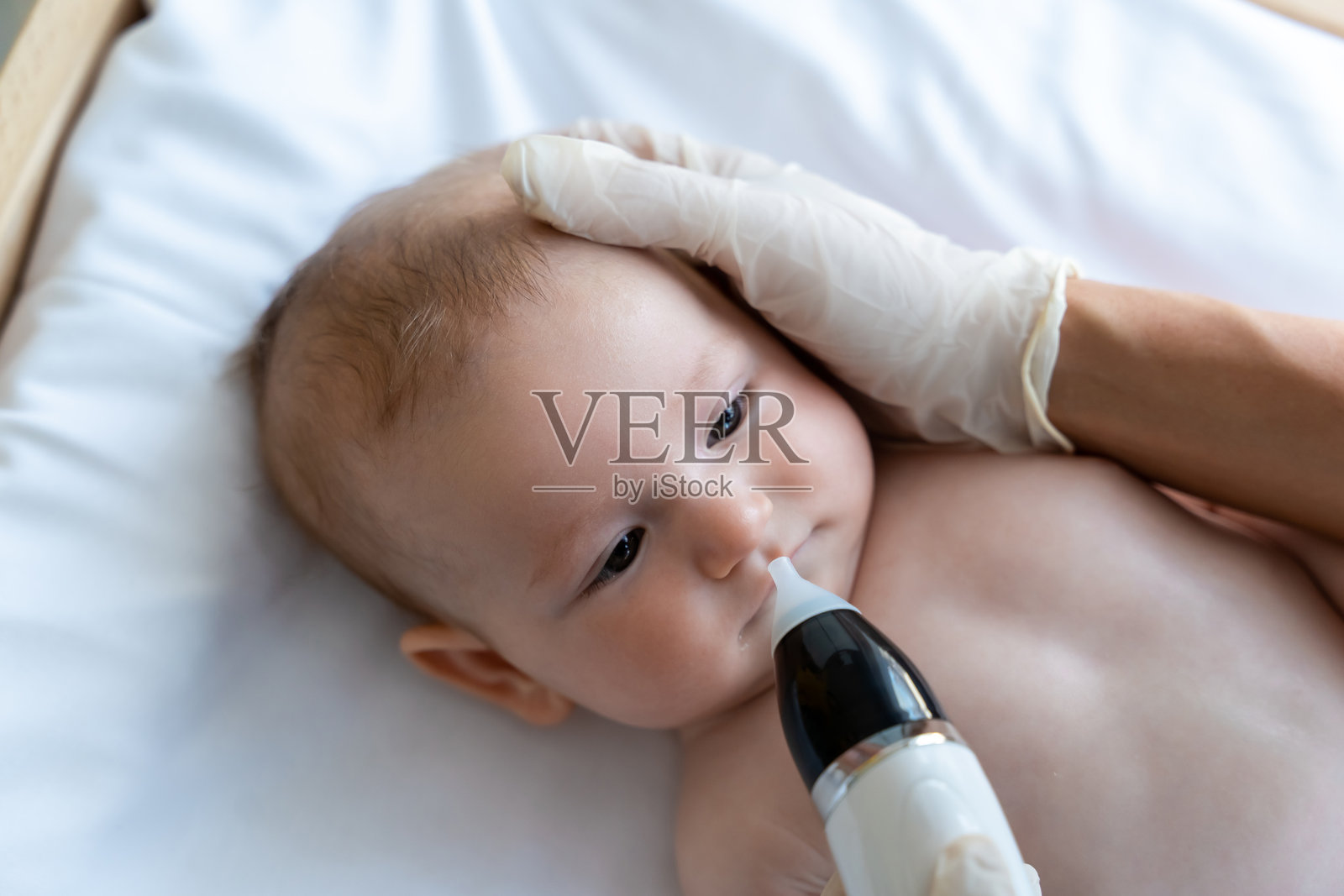 儿科医生检查女婴或男婴的鼻子照片摄影图片