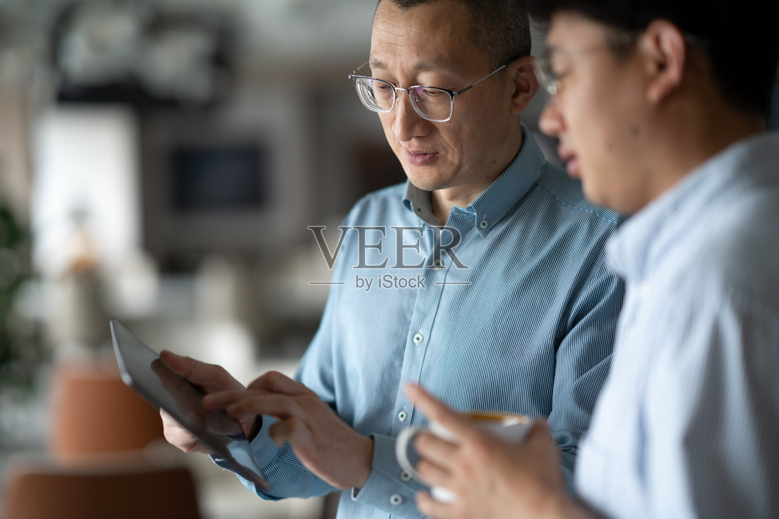 商务人士在办公场所使用平板电脑洽谈业务照片摄影图片