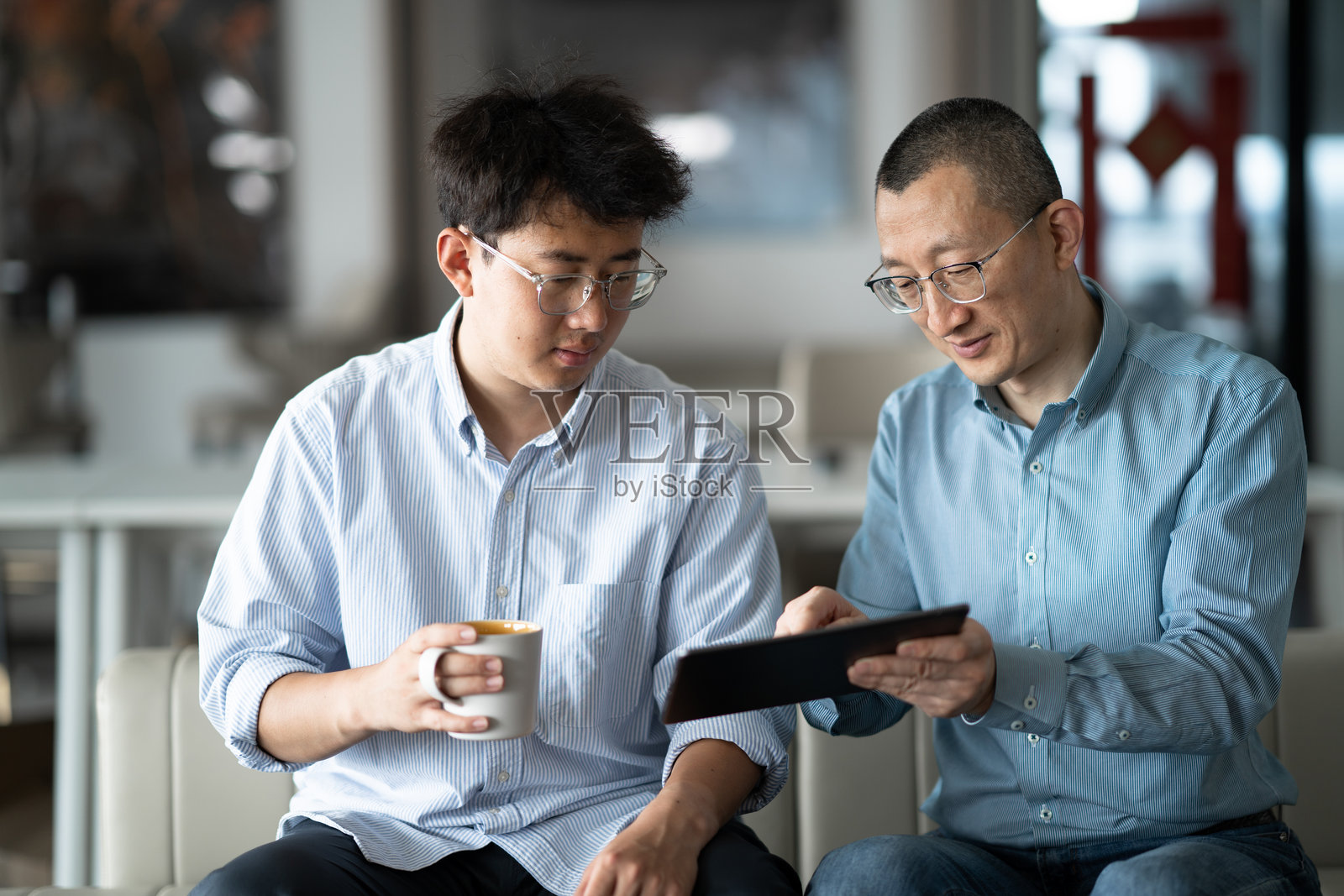 商务人士在办公场所使用平板电脑洽谈业务照片摄影图片