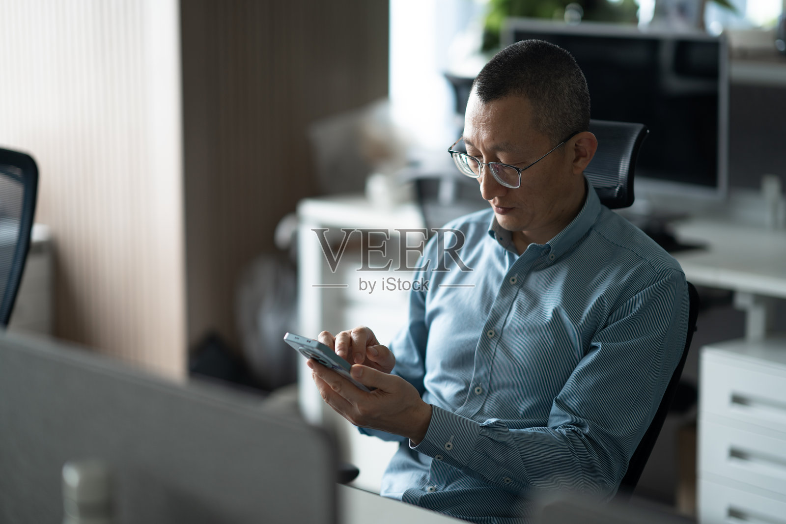 商务人士办公场所使用智能手机照片摄影图片