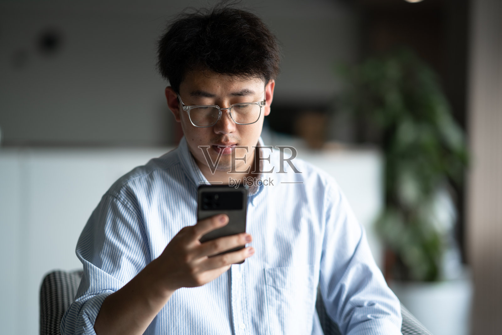 商务人士办公场所使用智能手机照片摄影图片