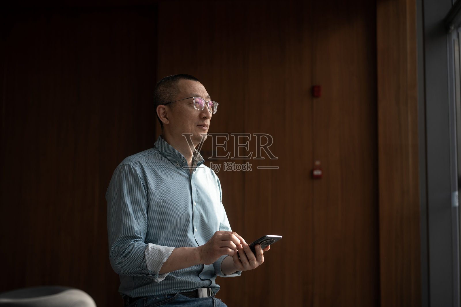 商务人士大厅内使用手机照片摄影图片