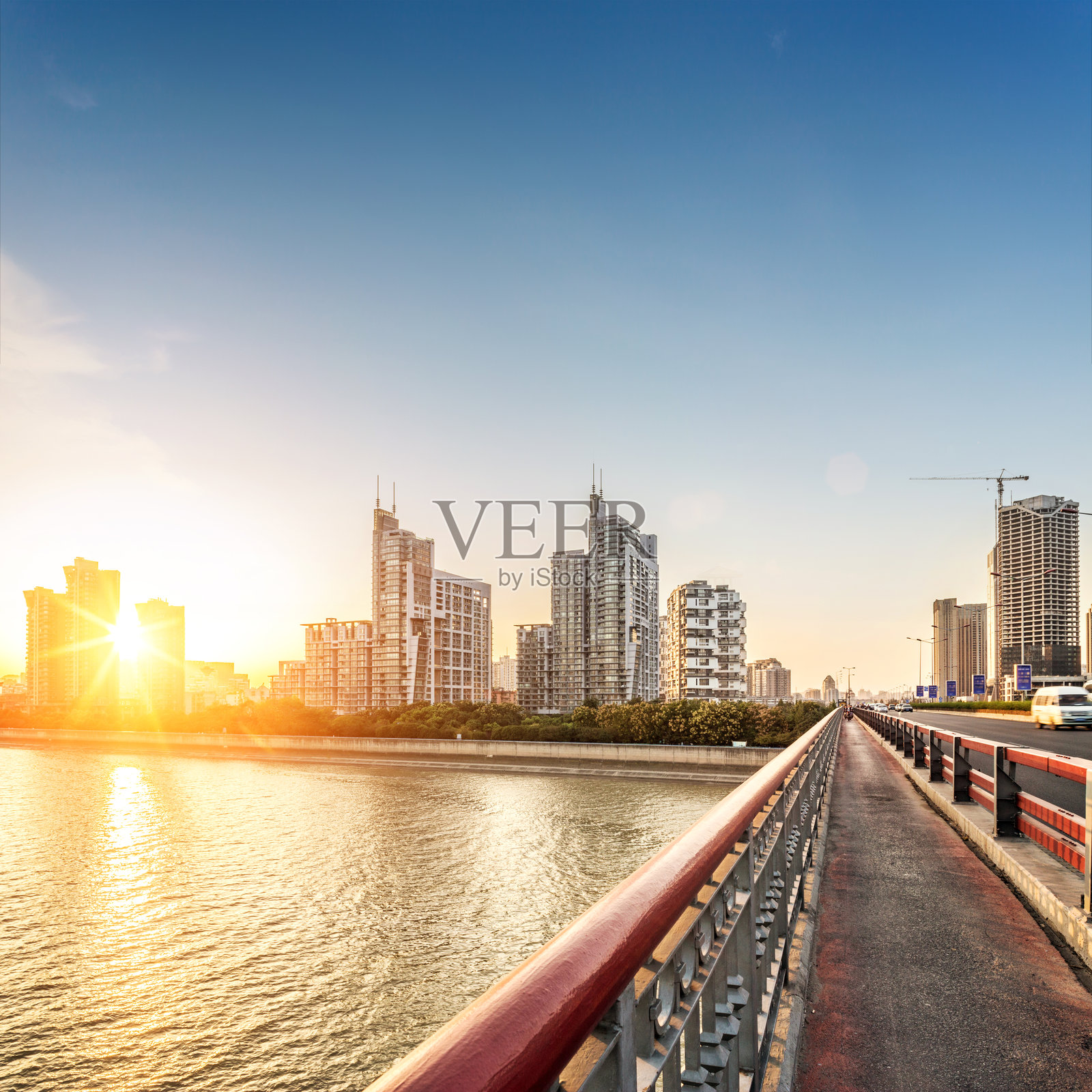 夕阳下钱塘江非机动车道和都市风光照片摄影图片