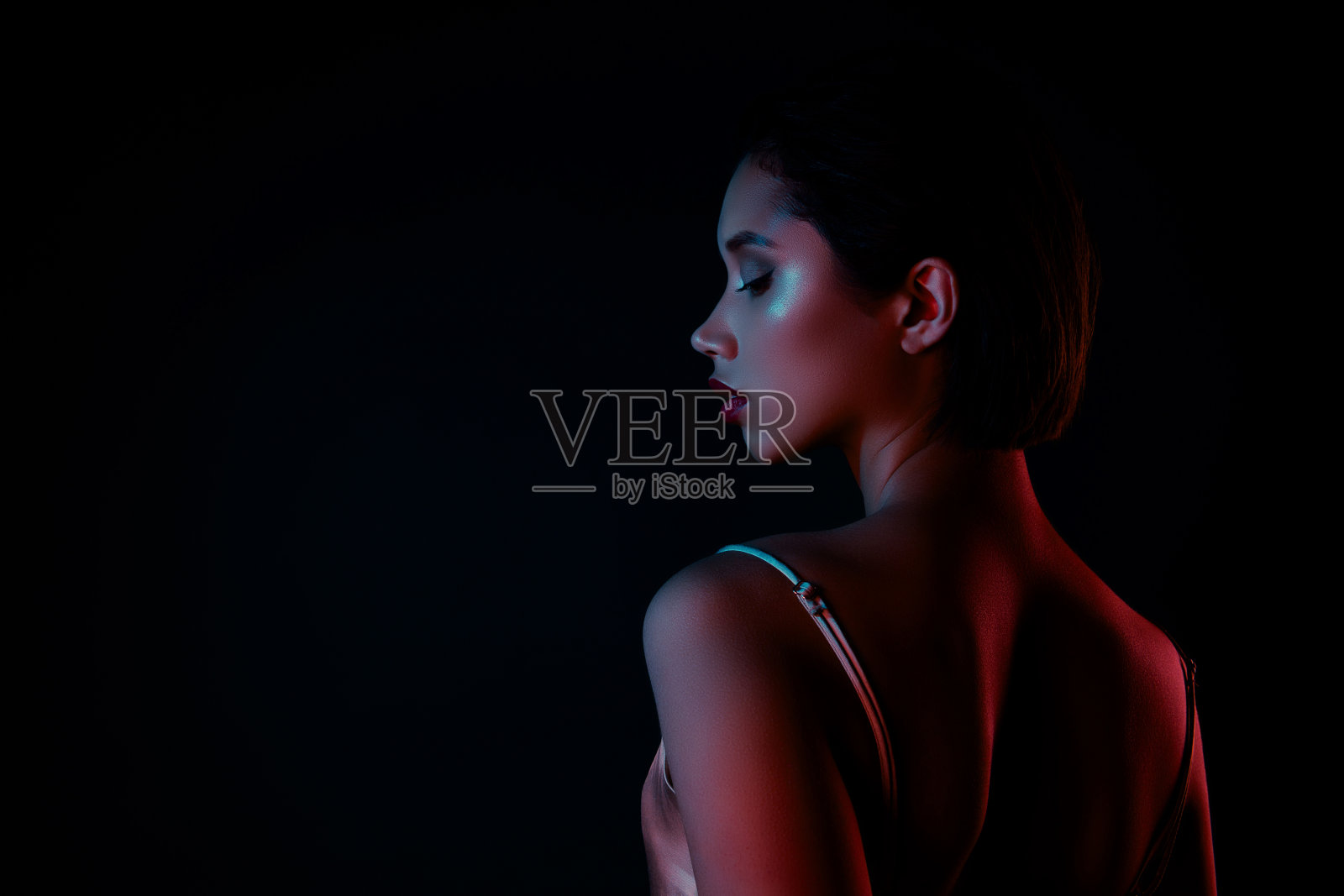 照片中快乐漂亮的女士穿着优雅的礼服享受着夜生活，空旷的空间孤立的黑色背景照片摄影图片