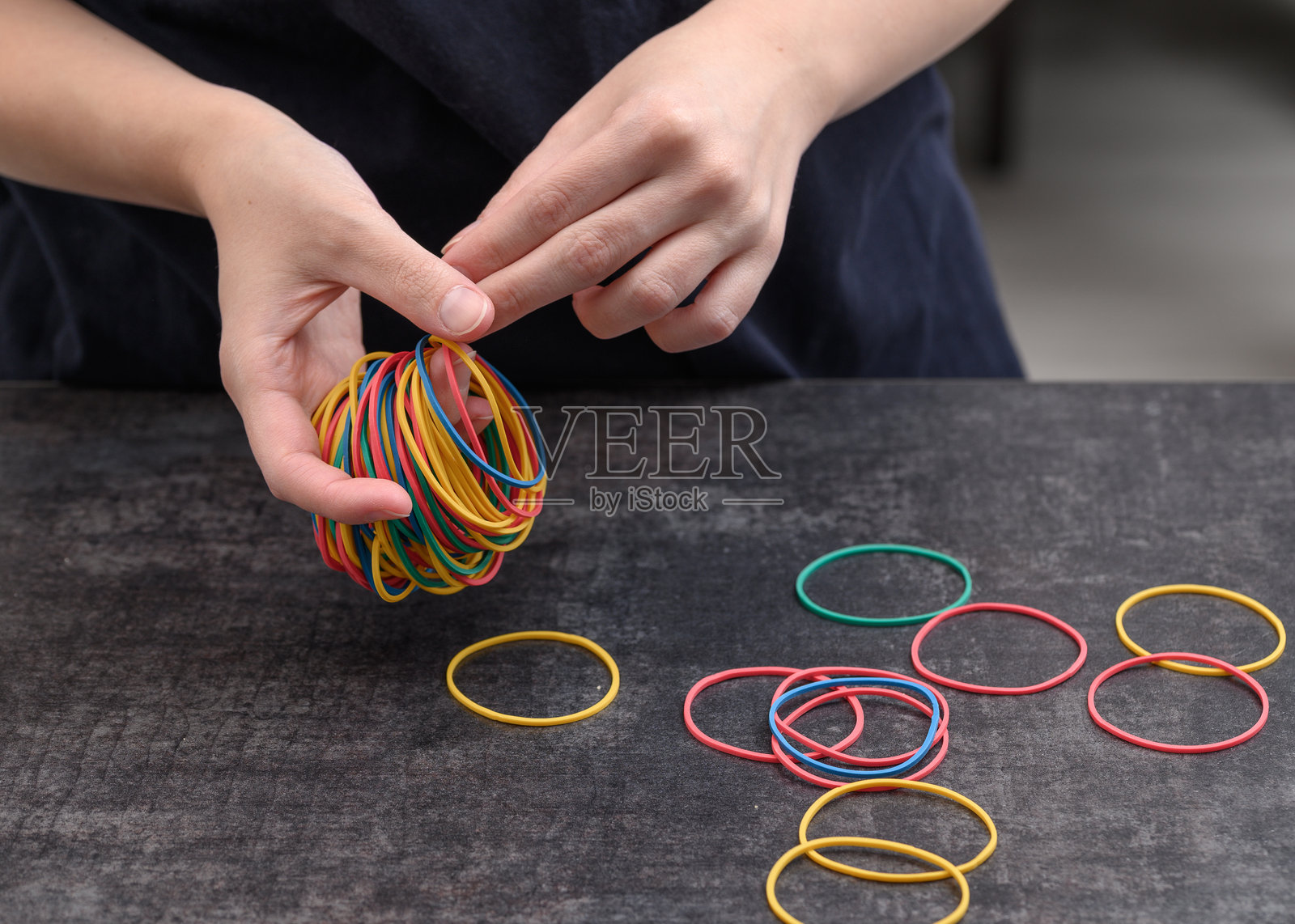 手里拿着五颜六色的橡皮筋照片摄影图片