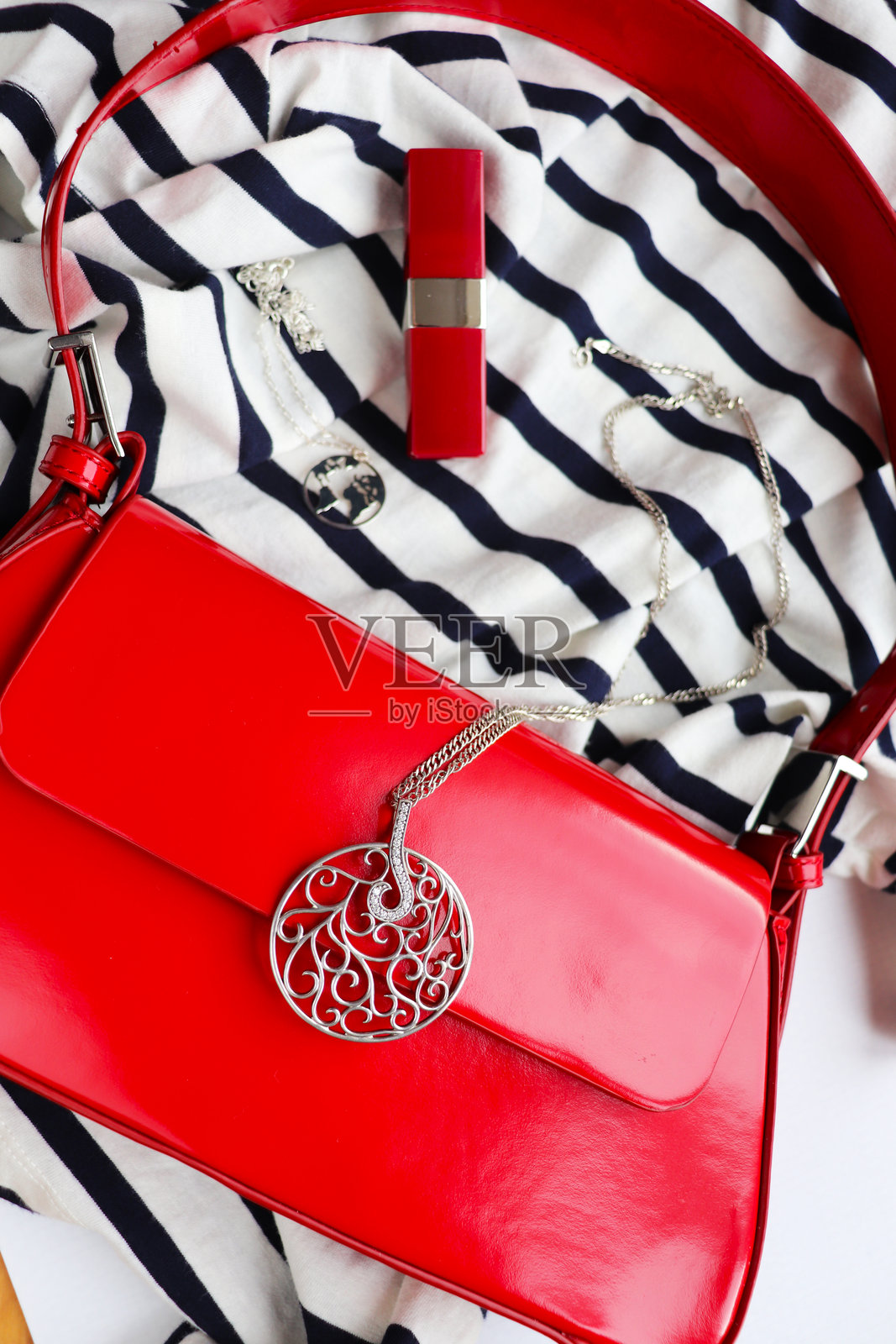 时尚风格。女性搭配红色手袋和银饰照片摄影图片