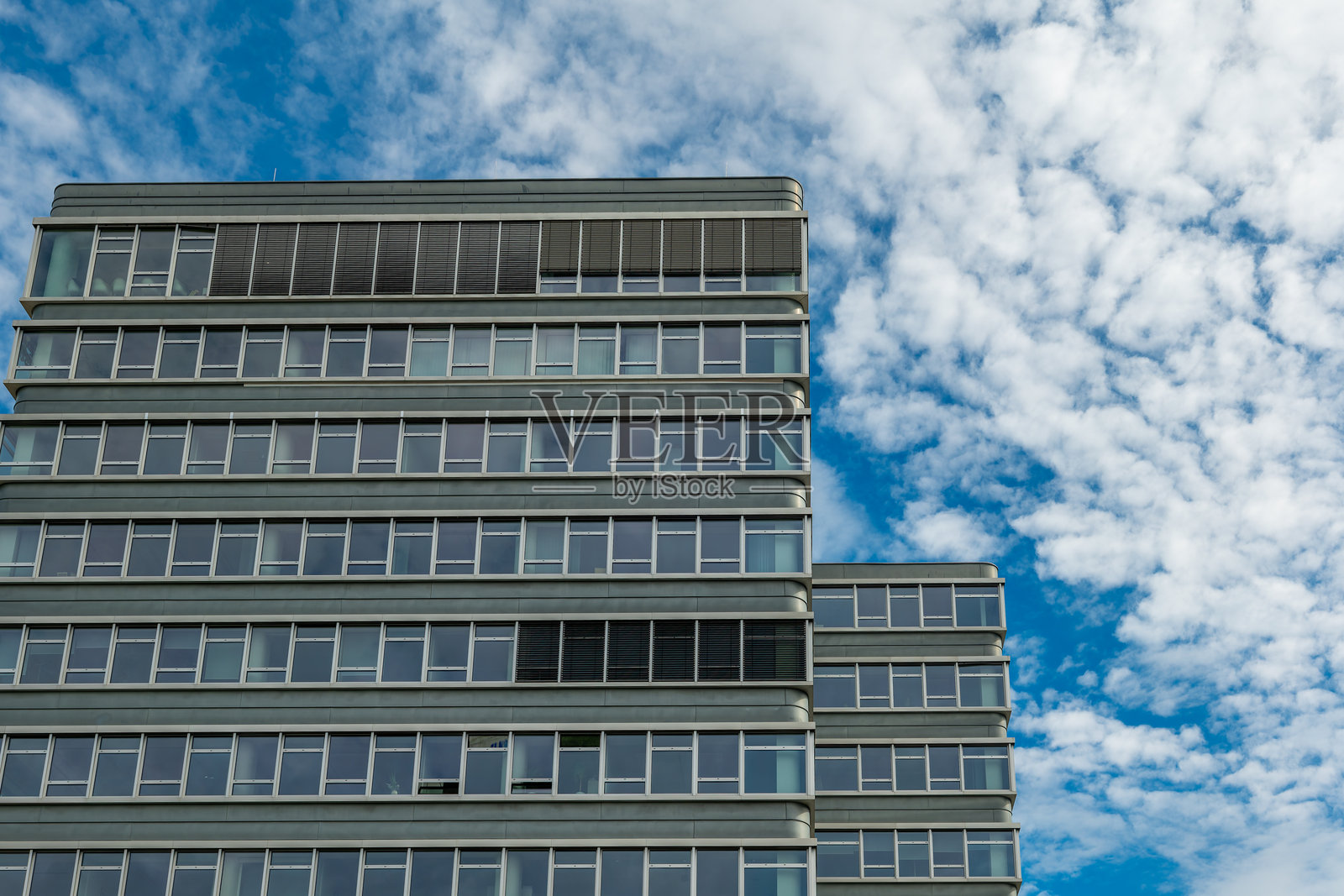 有很多窗户的高楼，背景是多云的天空照片摄影图片