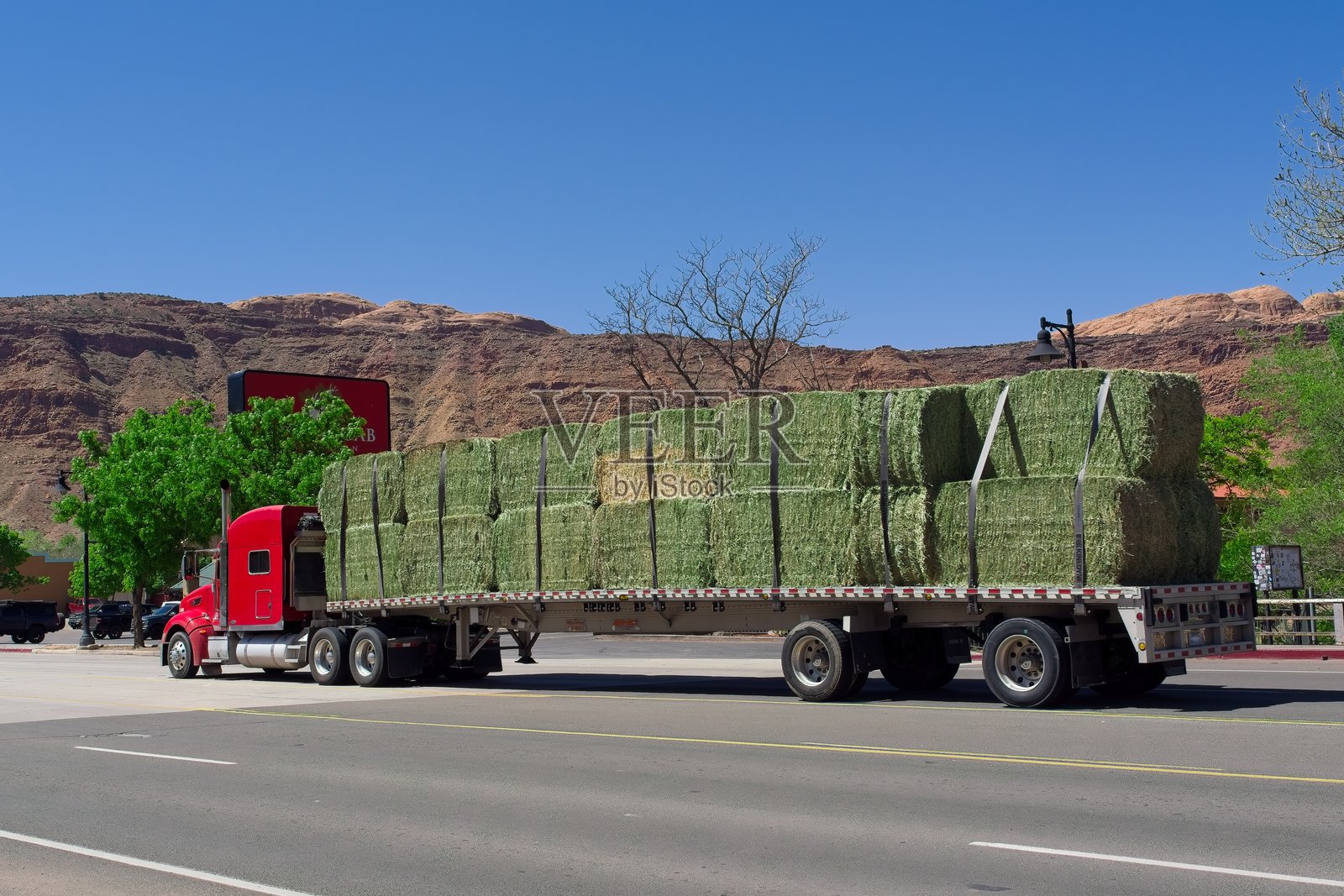 半拖拉机拖车卡车与干草捆移动通过主要街道在摩押犹他州照片摄影图片