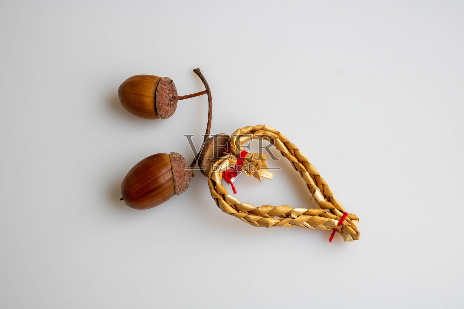 两颗橡子和一颗稻草做成的心是爱情的概念。照片摄影图片