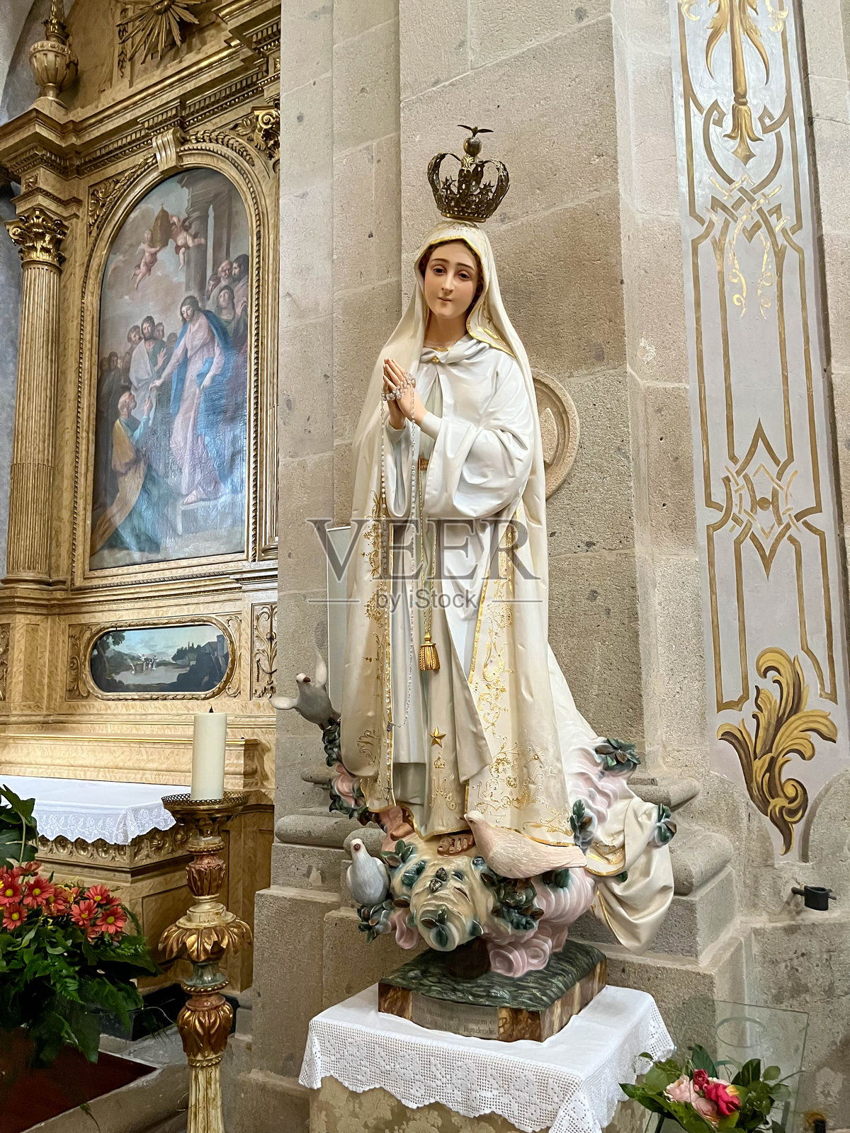 在葡萄牙布拉加，蒙特邦耶稣的圣图里奥·多萨梅罗大教堂里，Fátima圣母带着王冠和双手合十祈祷的形象。照片摄影图片