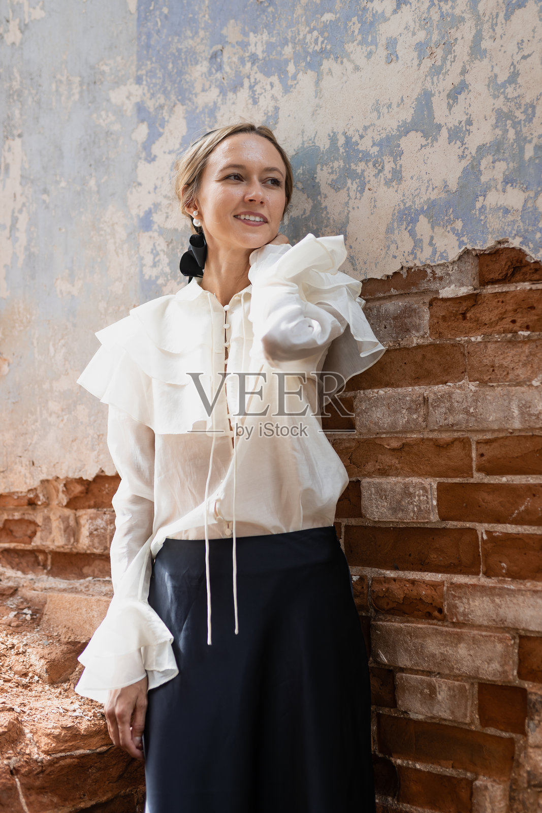 年轻女子站在砖房的废墟上，满目疮痍，灾难不断照片摄影图片