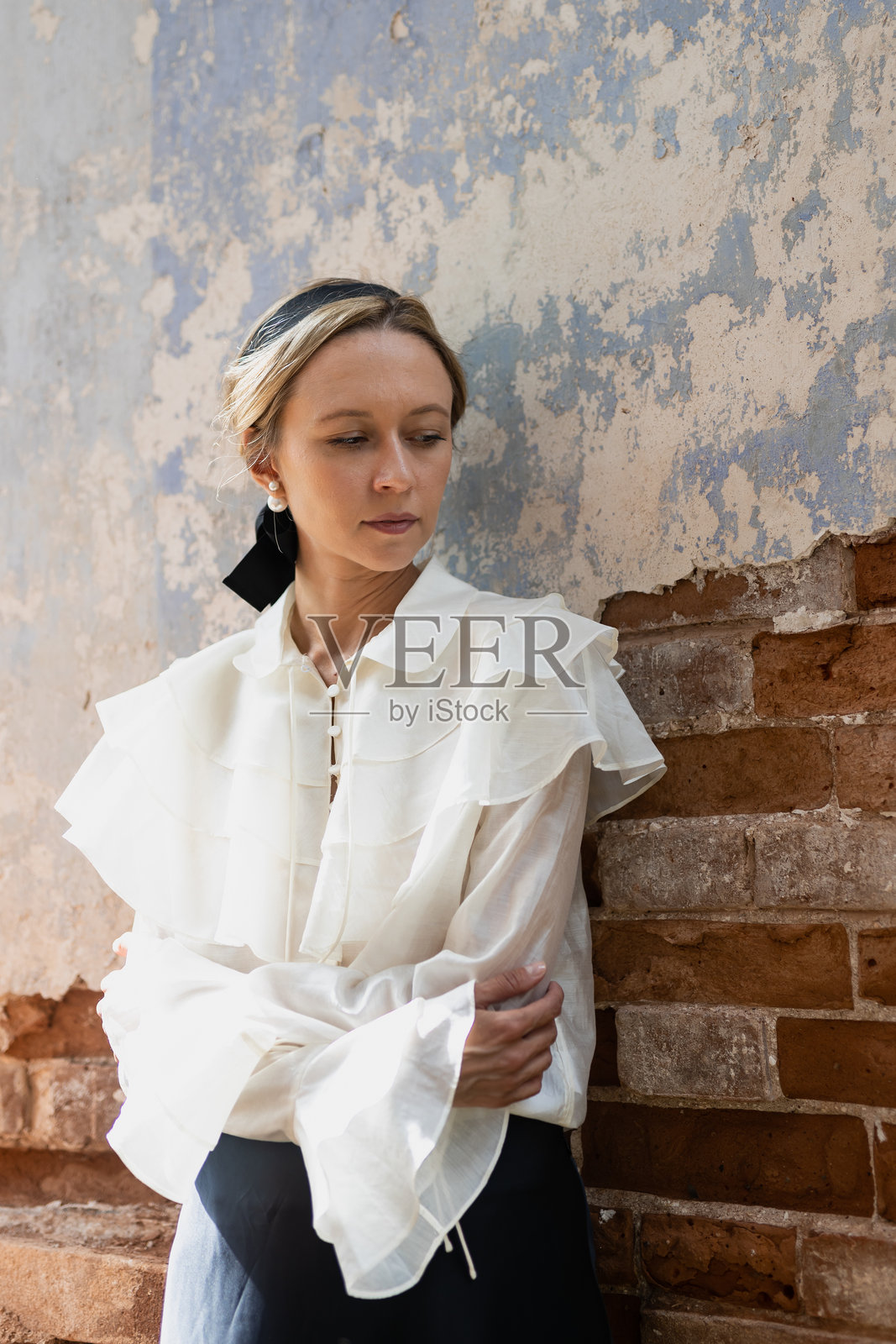 年轻女子站在砖房的废墟上，满目疮痍，灾难不断照片摄影图片