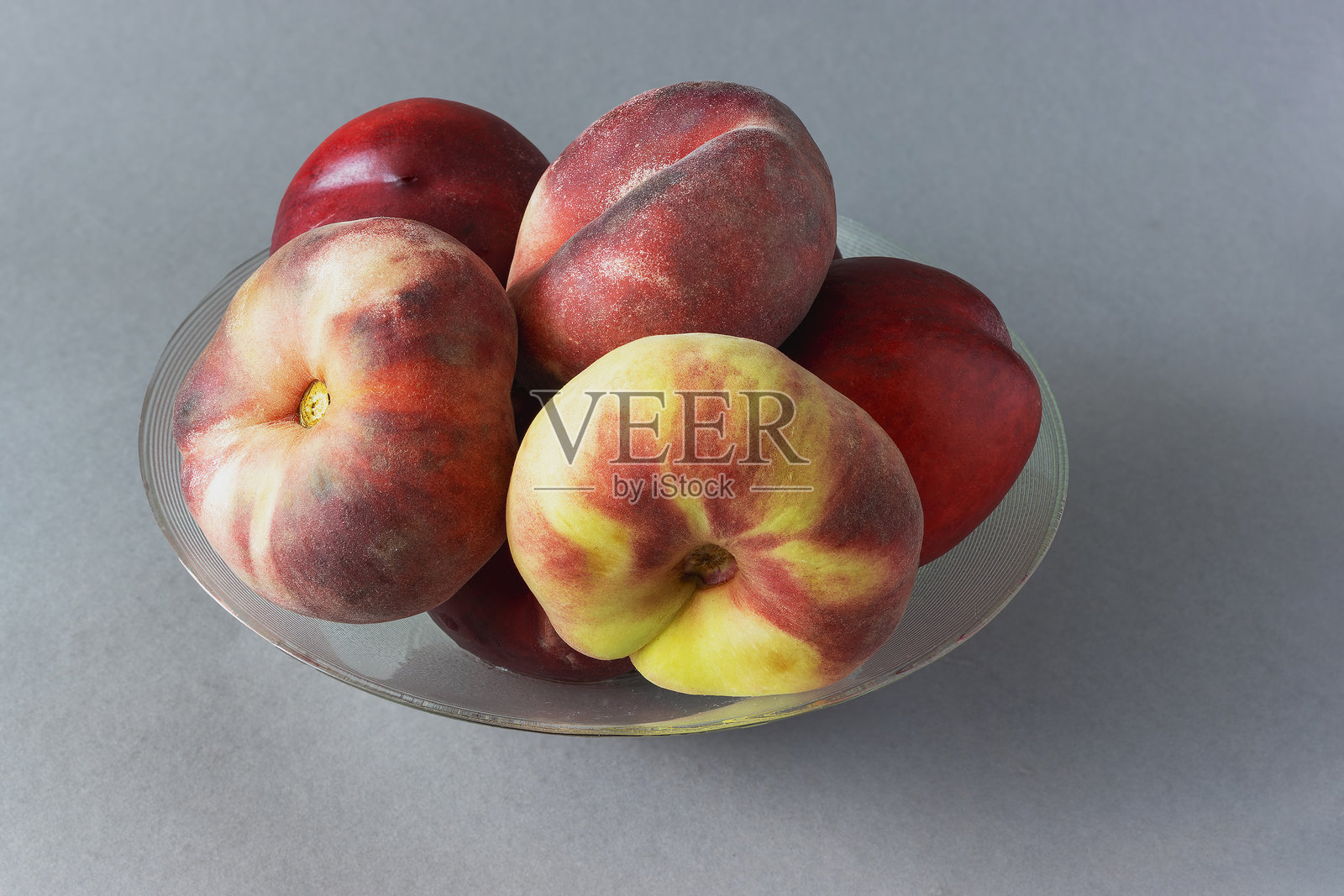 新鲜成熟的甜甜圈桃子和油桃在一个碗近距离照片摄影图片