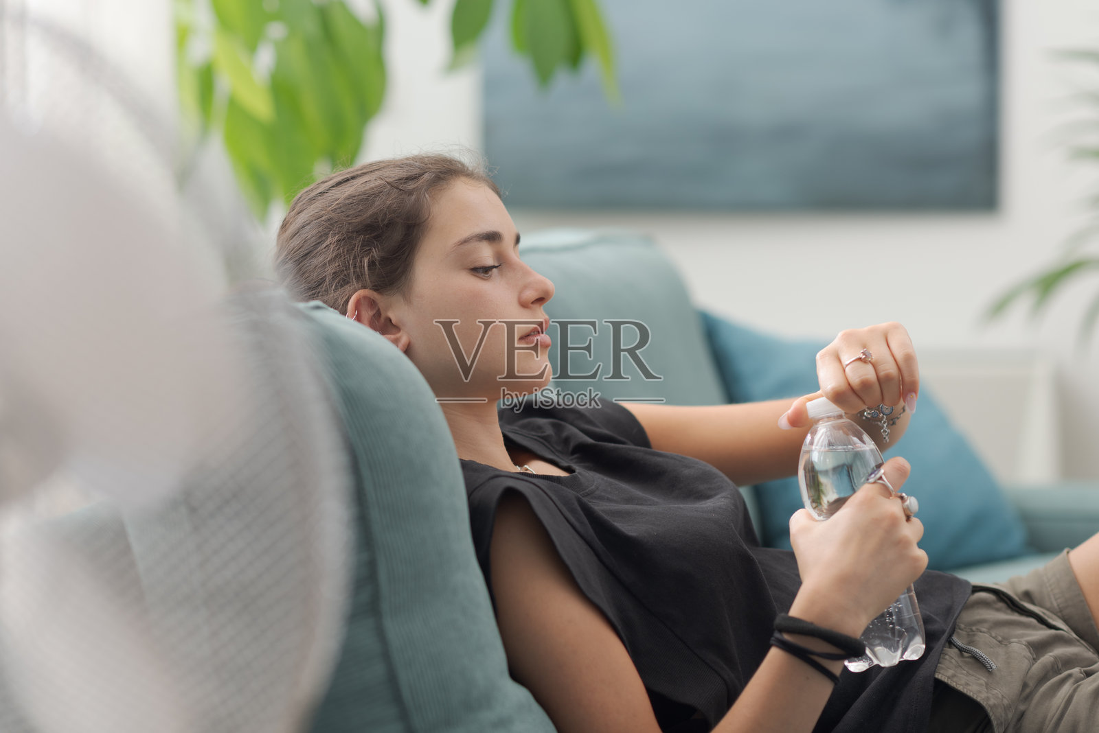 女人在沙发上喝水休息照片摄影图片