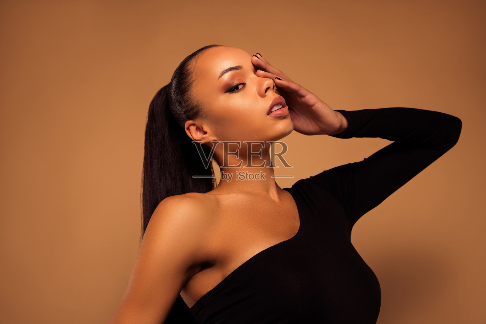 令人惊叹的可爱漂亮女人的肖像手盖脸烟熏眼睛化妆孤立的米色背景照片摄影图片