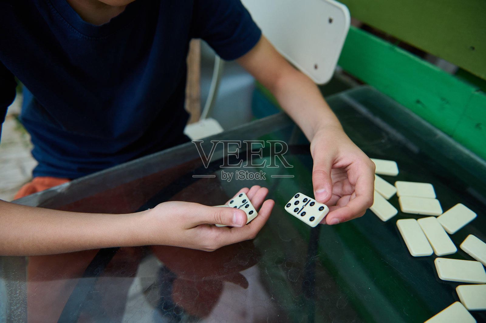 孩子在桌子上玩多米诺骨牌游戏，享受休闲活动，专注于注意力和乐趣照片摄影图片