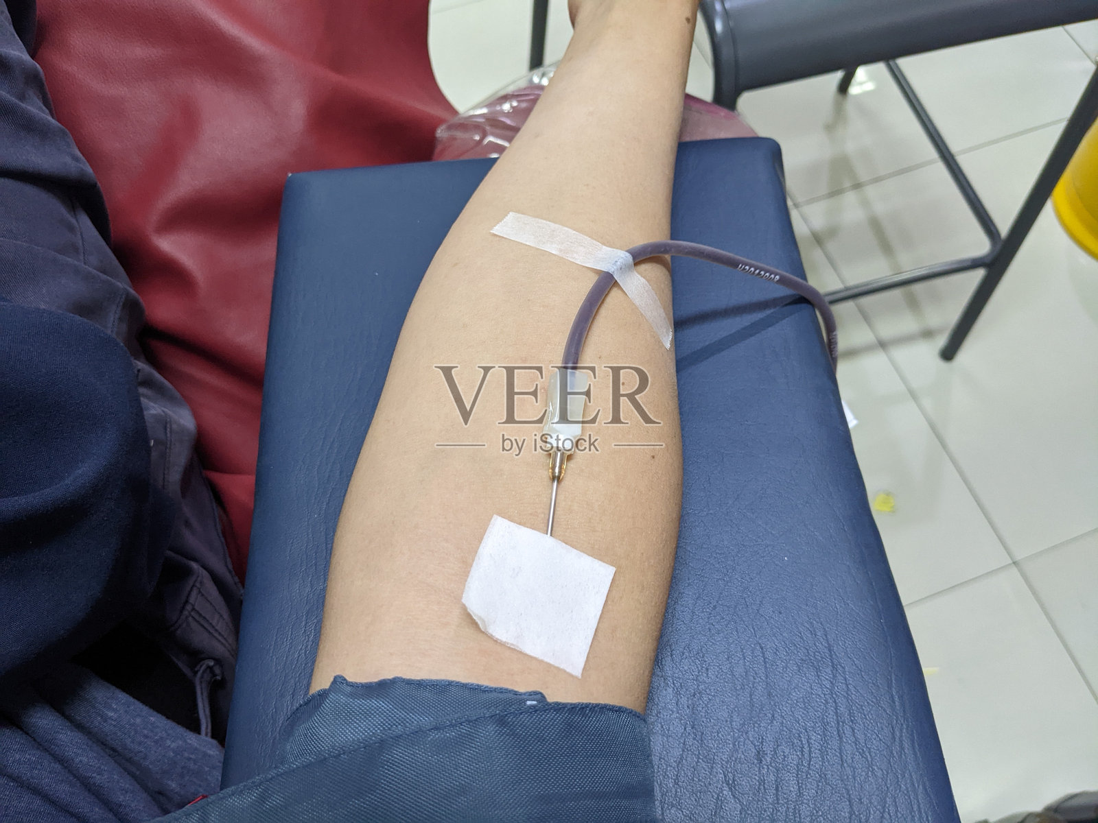 一个人的手臂上插着献血针。照片摄影图片