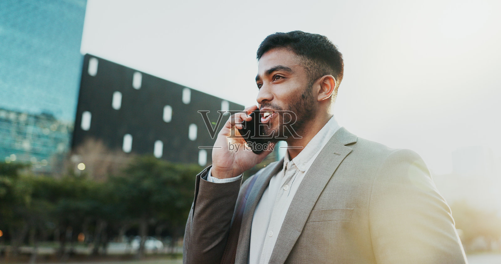 商务，男人和微笑与电话在城市为公司咨询，网络或好消息。专业人士，员工和智能手机在城市城镇的人行道上交流和交谈照片摄影图片