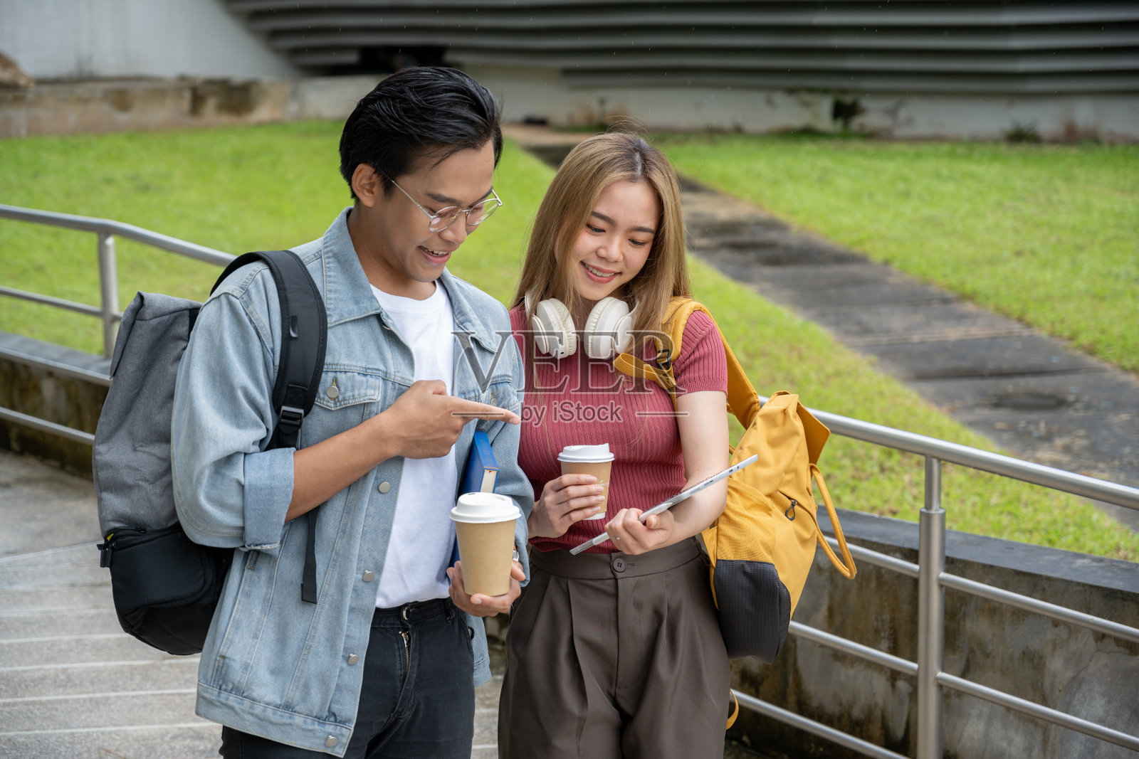正在户外散步的一名亚洲女大学生正在和她的男性朋友聊天照片摄影图片
