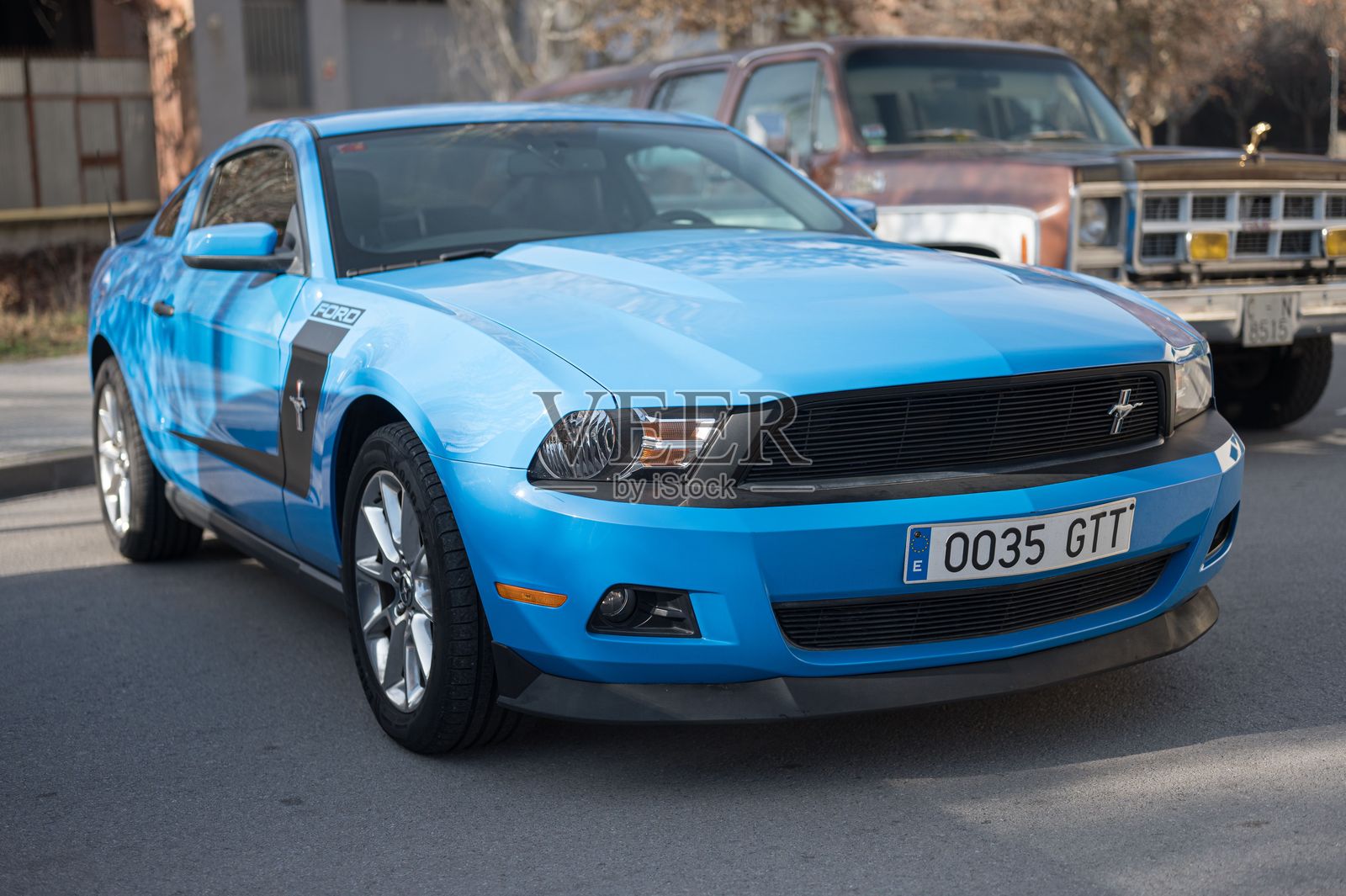 它是蓝色的，侧面有一条黑色条纹。无懈可击停在街上照片摄影图片