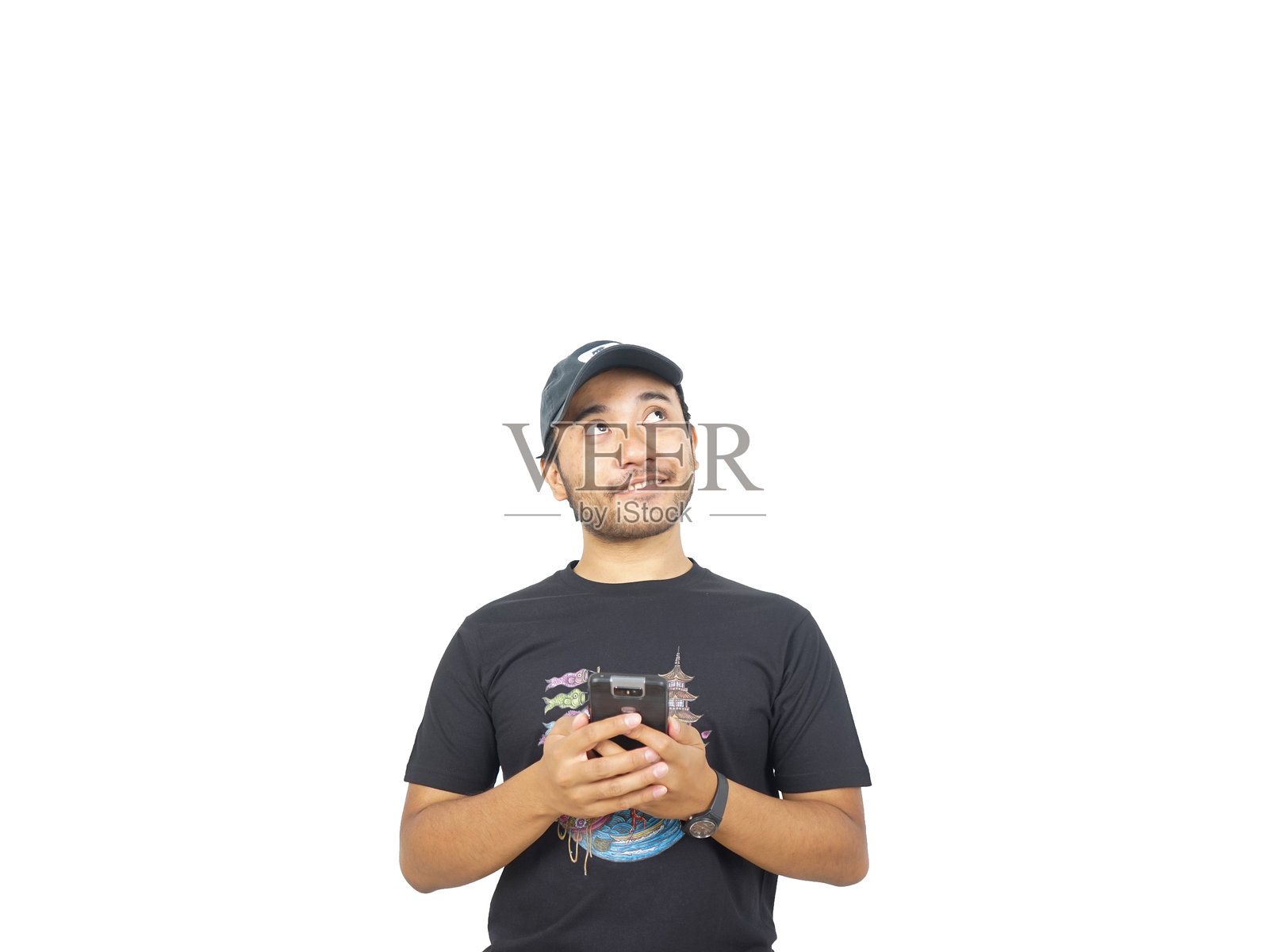 一名身穿黑色衬衫的亚洲男子双手拿着智能手机，面带微笑向上看照片摄影图片