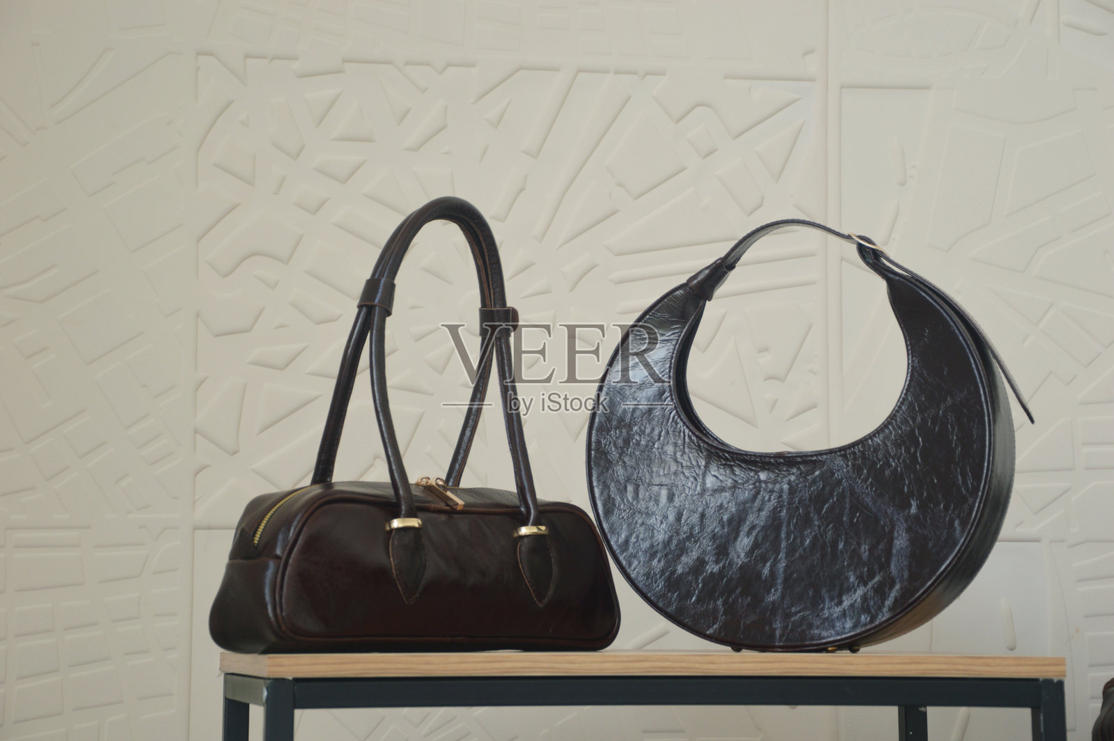 靠白墙的架子上放着两个黑人妇女的包。都市时尚风格。女性的配件。照片摄影图片