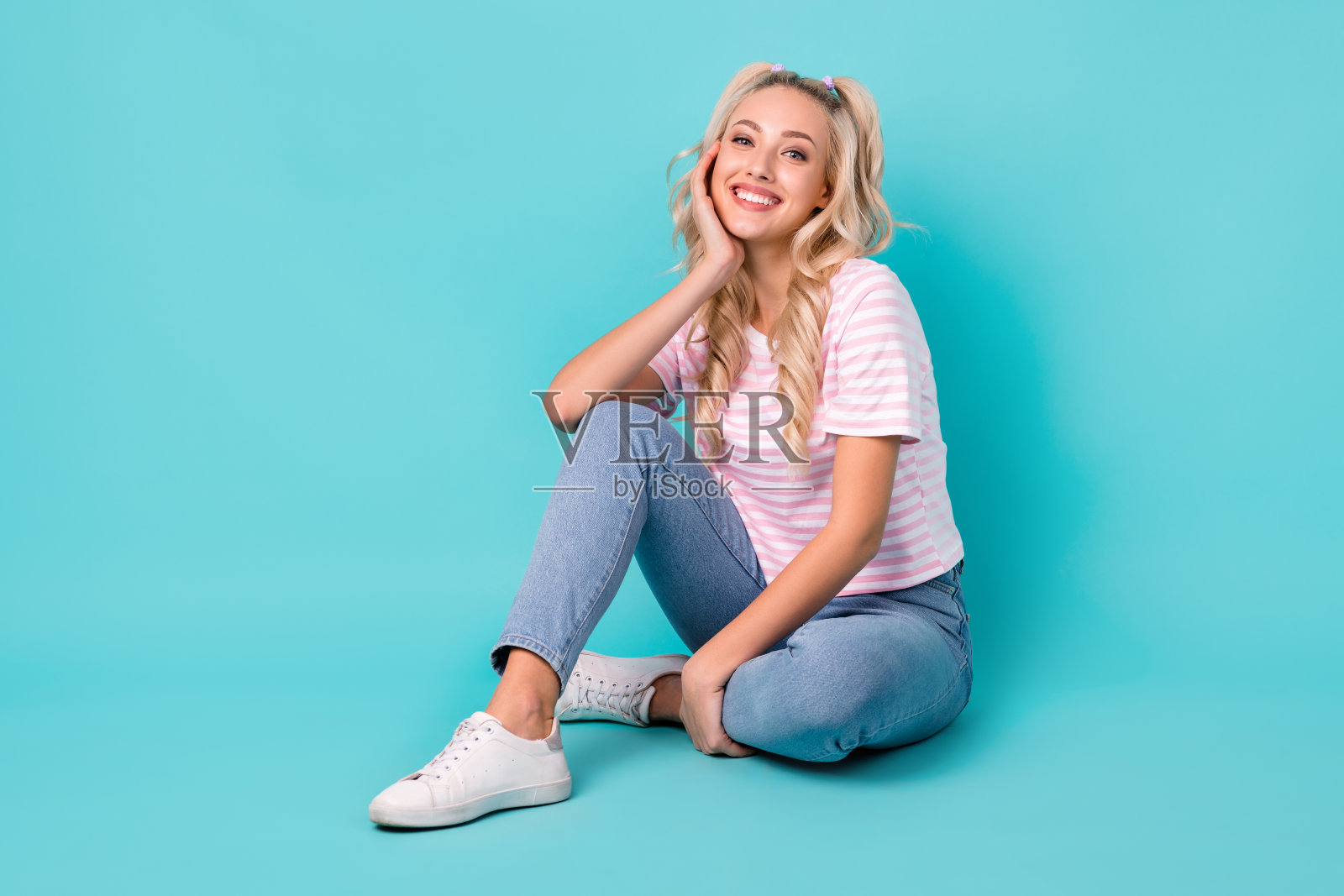 全长照片乐观可爱的女孩条纹t恤牛仔裤坐在手臂上的颧骨孤立在生动的绿松石色背景照片摄影图片