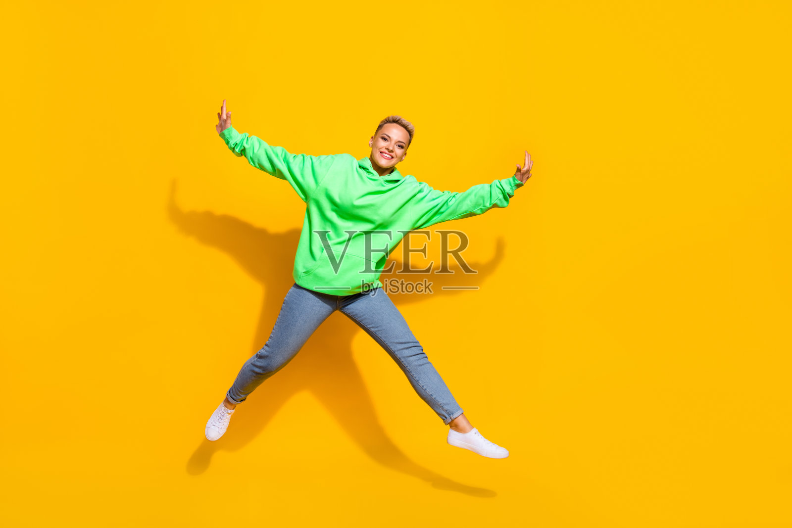 漂亮的喜出望外的人的全长肖像，牙齿微笑跳跃孤立的黄色背景照片摄影图片