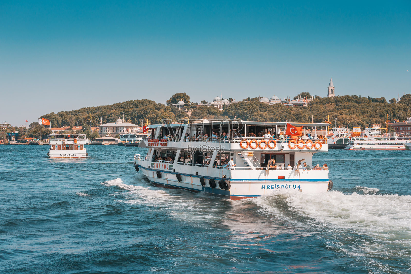 一艘在博斯普鲁斯海峡航行的渡轮，在运送乘客的同时，还能欣赏到城市美景。照片摄影图片