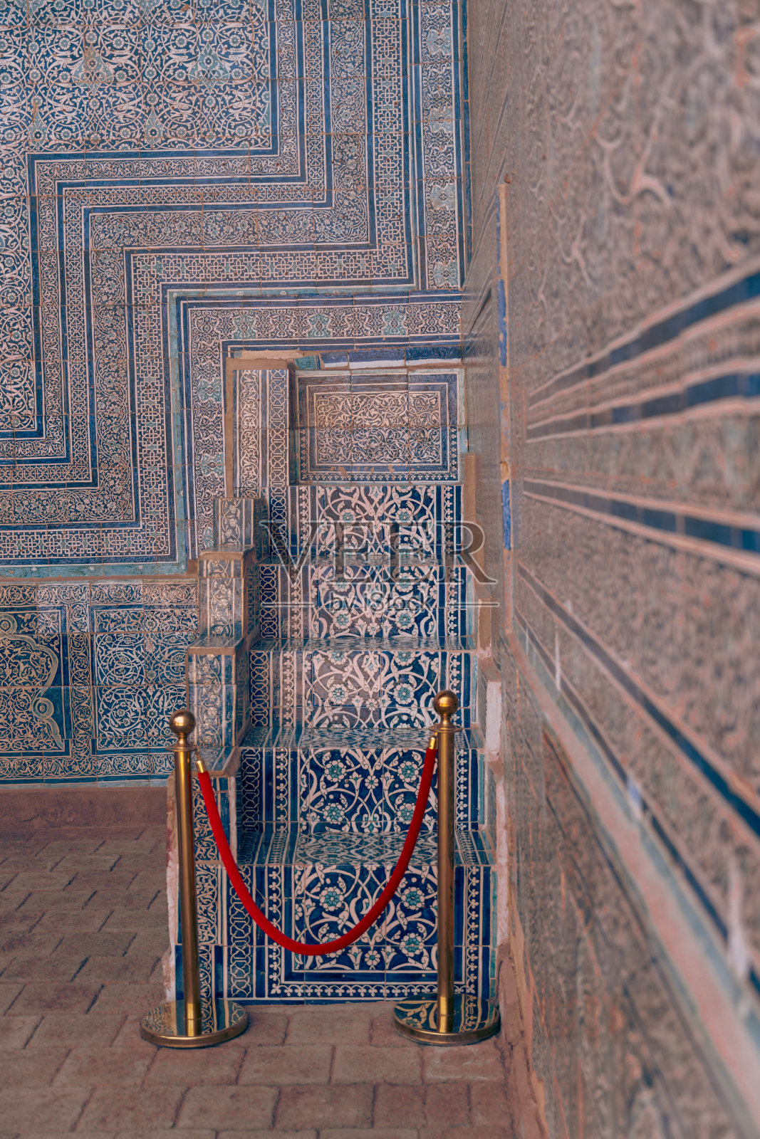 一面蓝白相间的墙，中间有一根红绳子。绳子系在金属栏杆上照片摄影图片