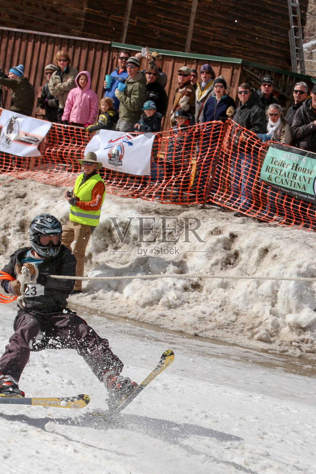 一名滑雪选手开始摔倒时,观众在一旁观看照片摄影图片