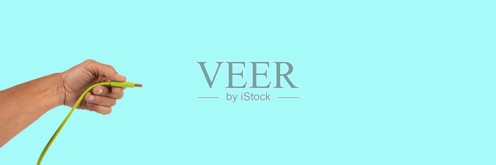 黑人男性的手拿着一根USB线，隔离在青色横幅背景上照片摄影图片